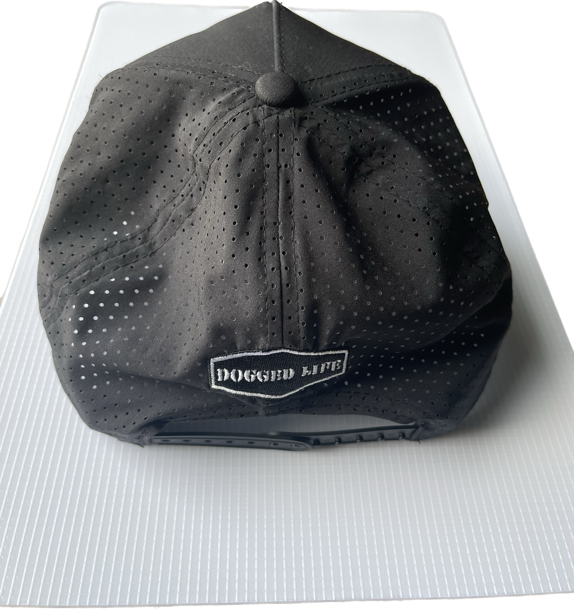 Dogged Life black perforated Tritech cap with Bongo Patch, moisture-wicking, lightweight, and SPF 30 protection.
